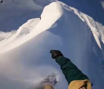 This guy riding the crest of a mountain.