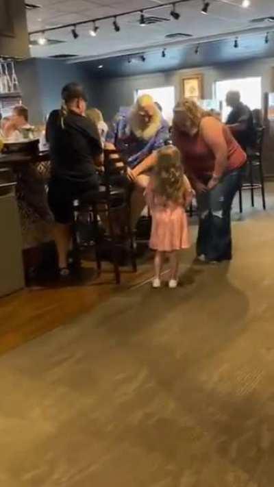 A little girl found Santa Claus at the bar while he was off the clock but Santa still had a chat with her