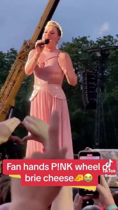 Fan gives P!nk a massive wheel of brie at London gig. 