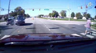 SUV runs a red light and crashes into another vehicle, while simultaneously avoiding pedestrian and vehicle recording (and lands on another car)