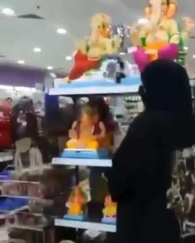 Ganesha idols being broken by a few black tents in a mall in Bahrain or Qatar.