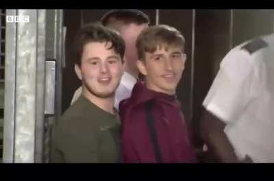 Two boys laughing on their way to court for killing a police officer, later on they were convicted of manslaughter.