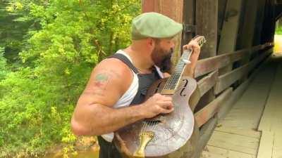 Playing slide guitar with a spoon in my mouth while fingerpicking on my old National Guitar.