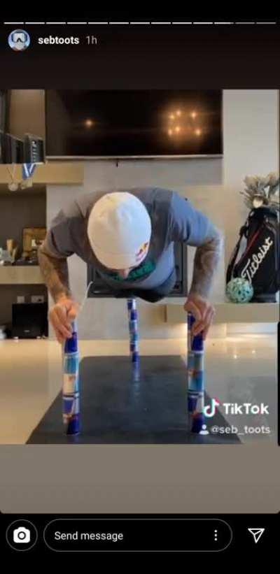 Pro snowboarder Sebastien Toutant doing push-ups on a stack of Redbull