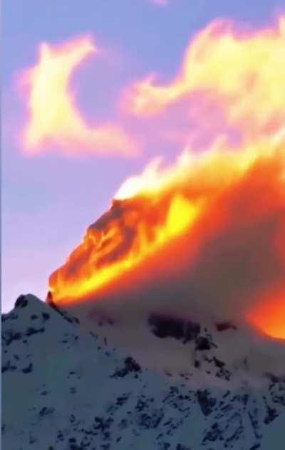 Sunset hitting the clouds on a mountaintop looks looks like an incredible wildfire. [December 2022]
