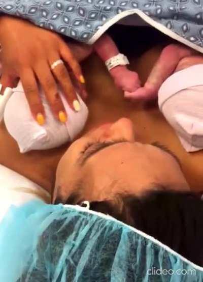 Twins hold hand right after birth.