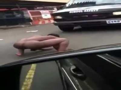 A naked man squatting screaming