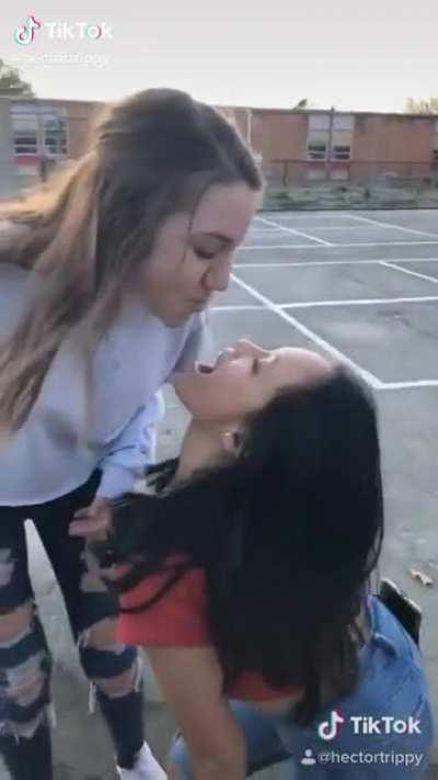 Girls at school in America drinking water out of each other’s mouths