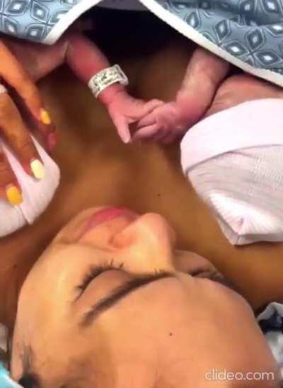 Two sisters holding hands after birth