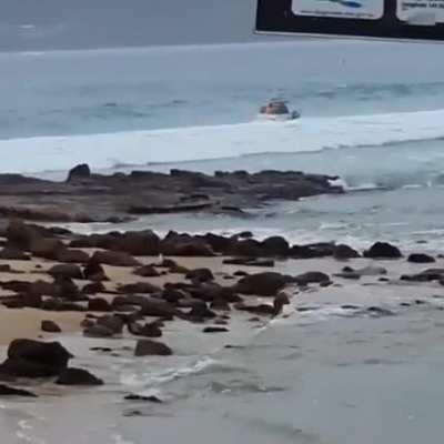 The boat is steering into a breaking wave.