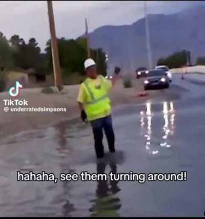 Worker makes traffic think puddle is deep