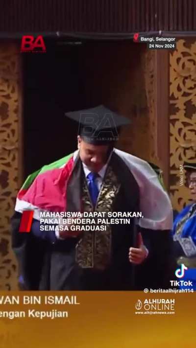 UKM student wears the Palestinian flag during graduation.