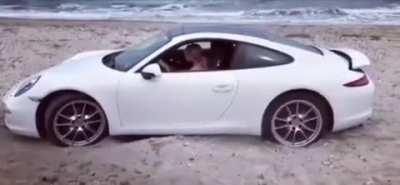 Genius tries to drive her Porsche on the beach