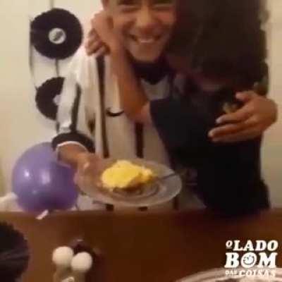 Felicidade do irmão menor ao receber o primeiro pedaço do bolo