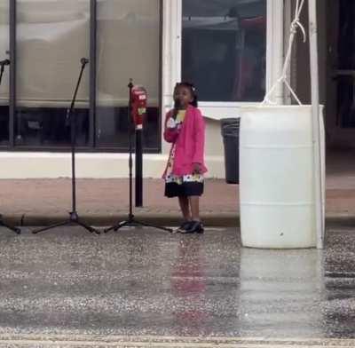 Little girl singing in the rain at a Juneteenth Celebration in front of the Rosa Parks Museum in Montgomery, AL.