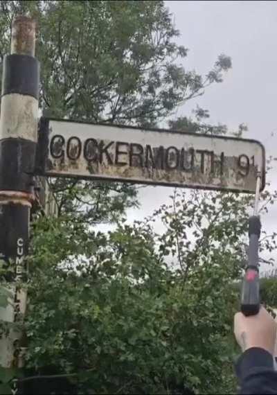 Pressure washing a road sign of an English town