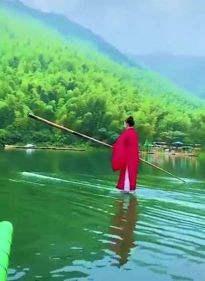 Riding a piece of bamboo like a stand-up paddle board