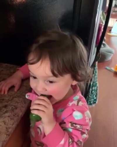 Kid trying pepper for the first time while parent films.