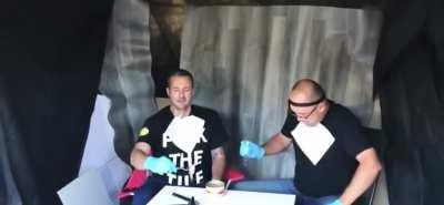 They are trying to eat surmströmming, worst smelling thing in the world.