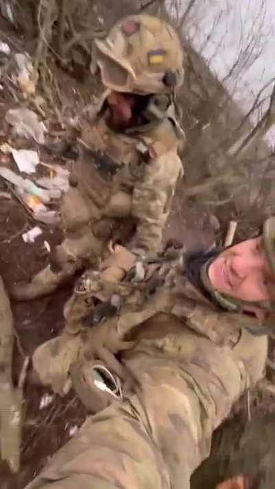Bakhmut defender Roman helps with the evacuation of a fallen brother from the battlefield.