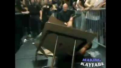 Mike Awesome powerbombs Masato Tanaka over the top rope, through a table, and then crashes onto him from off-screen while Joey Styles screams 