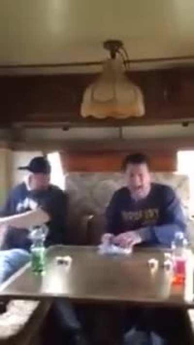 Two people trying to eat Surströmming (fermented fish!), A typical swedish dish. It is said that the smell is so strong that the recommendation is to open the can outside the house, inside a bucket full of water.