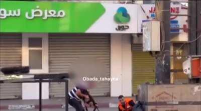 West Bank MEDIC passes weapon from downed militant to another who continues shooting at IDF. Today. Jenin.