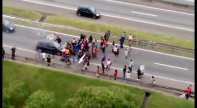 Protestors block highway traffic, the car doesn't care