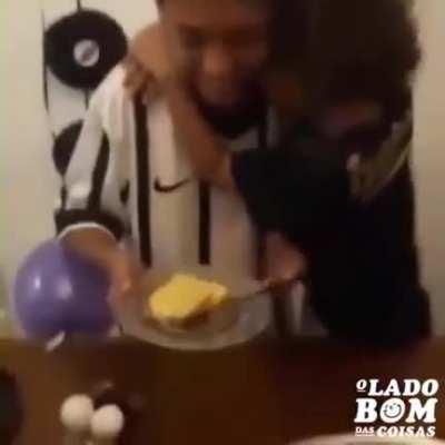 Little brother's reaction upon receiving the first piece of his brother's birthday cake.