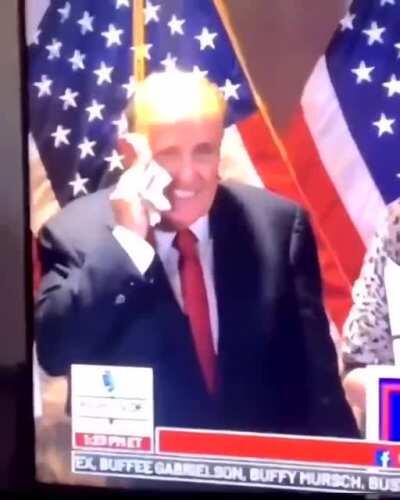 Rudy Giuliani blows his nose in a napkin then proceeds to wipe the snot all over his face.