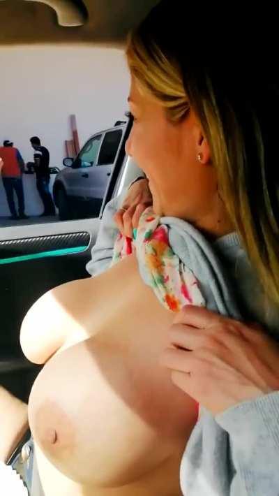 Flashing her big tits from the car to strangers