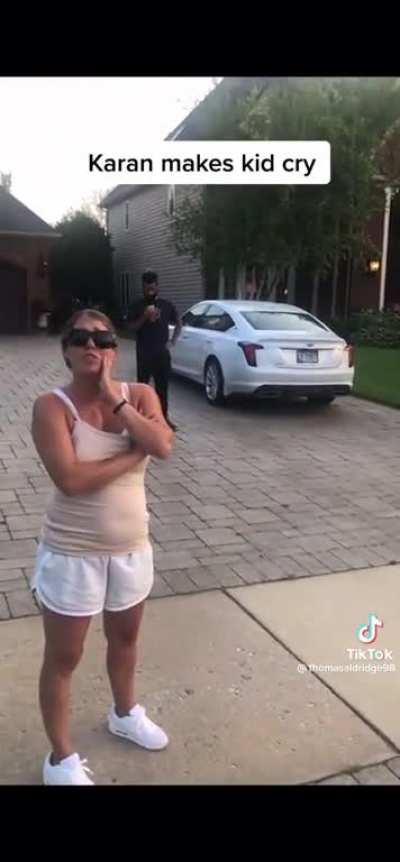 A grown woman accosts little black girls for watering their neighbor's flowers