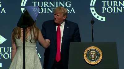 A sweaty Trump begs a young woman for a kiss on stage after giving a speech...