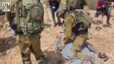 Israeli soldiers kneel on the neck of an elderly Palestinan man