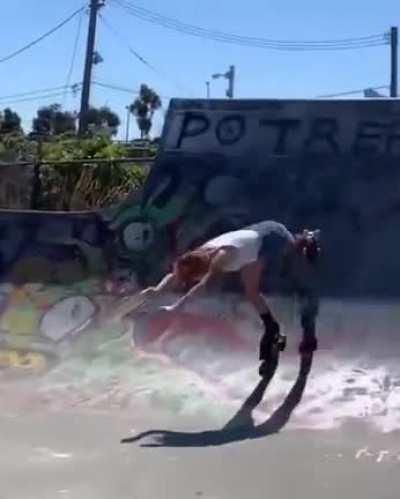 Rollerskater at skate park going backwards and does a flip for the finish.