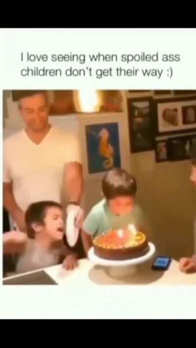 Spoiled brat tries to blow birthday candles .