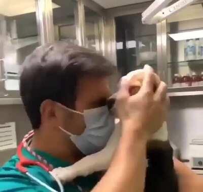 Medical professional having to deal with an unruly patient trying to take off their mask