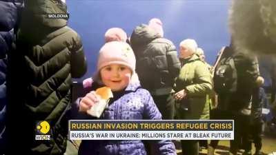 A Ukrainian little girl in Moldova smiling and offering her food to the cameraman