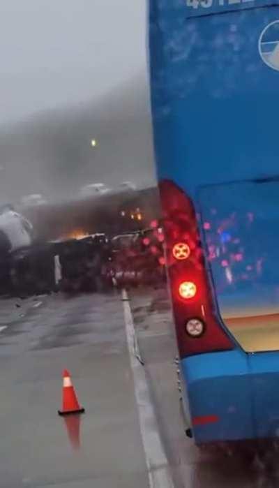 A truck tumbles over the side of a freeway and lands on the wreckage from an earlier crash.