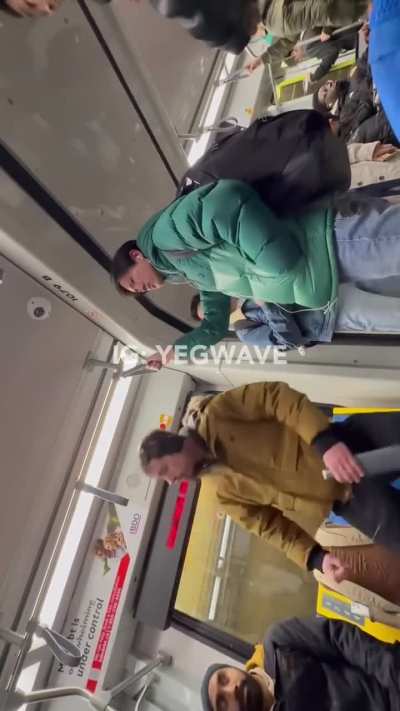 Man starring intensely at a muslim girl on a subway while another man intervenes.