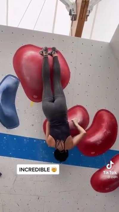 Oriane Bertone forgetting to struggle while rock climbing indoors