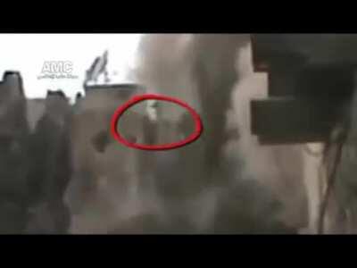 Syrian soldier's cover disappears around him before he falls through the floor of a collapsing high-rise