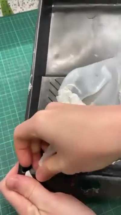 Peeling off dried glue from a tray