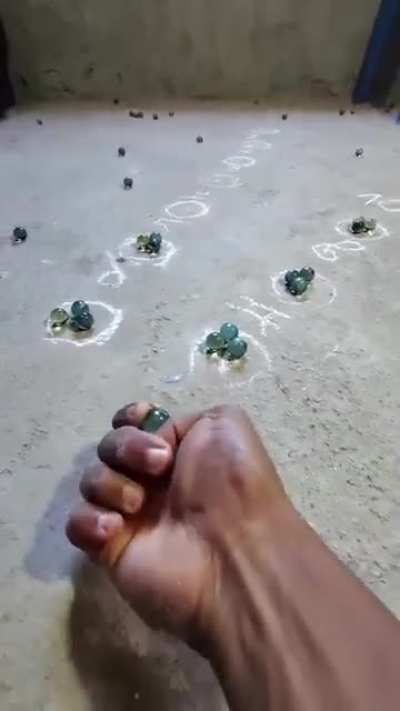 Perfectly aiming marbles with thumb in marbles game(source link in description)