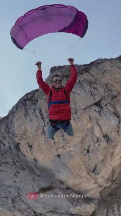 Man paraglides on teeny wing.