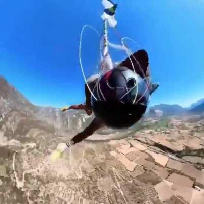 Paraglider narrowly avoids crashing into the ground.