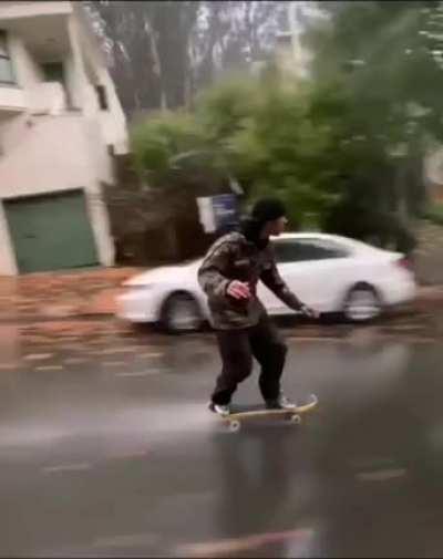 Skateboarding down a steep rainy road
