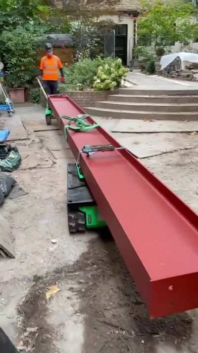 Transporting I-beam through narrow streets on a tracked carrier
