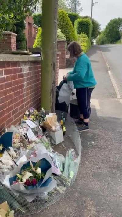 Woman destroying a flower tribute for a teenager that recently died in a car accident.