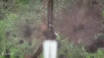 A wounded soldier is pelted with grenades from a drone, but he simply throws them away